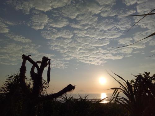 a sunset over the ocean with the sun in the sky at Time Travelodge Homestay in Zhuangwei
