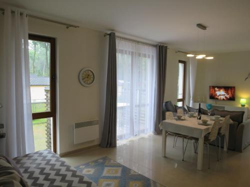 a living room with a dining table and a living room with at Sea Life Apartment in Rewal