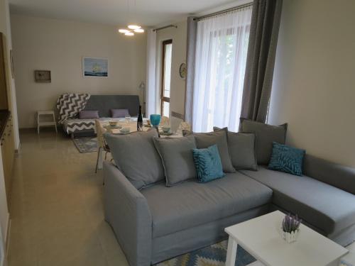 a living room with a couch and a table at Sea Life Apartment in Rewal