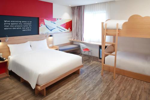 a hotel room with a bed and a desk at Ibis Saigon Airport in Ho Chi Minh City