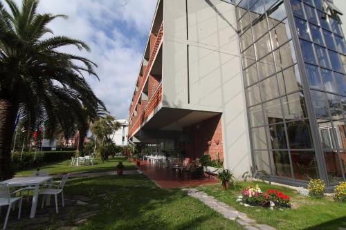 a building with a table and chairs in front of it at Hotel Marina in Marina di Massa