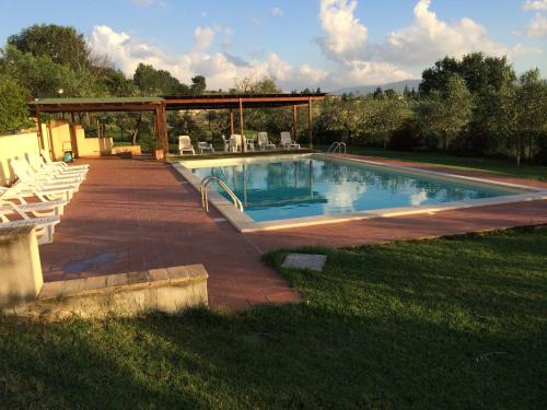 a swimming pool with chairs and a gazebo at Agriturismo San Marco in Montefalco