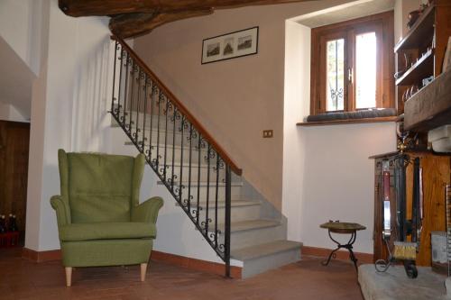 a living room with a staircase and a green chair at Casa Martino in Villa