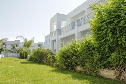 a white apartment building with a green yard at Blumarine Residence Club in Ostuni
