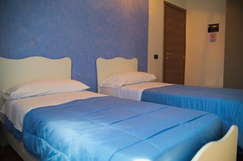 two beds sitting next to each other in a room at Cialoma B&B in Palermo
