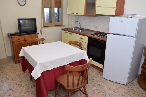 uma cozinha com uma mesa branca e um frigorífico branco em La Scogliera B&B em San Vito Chietino