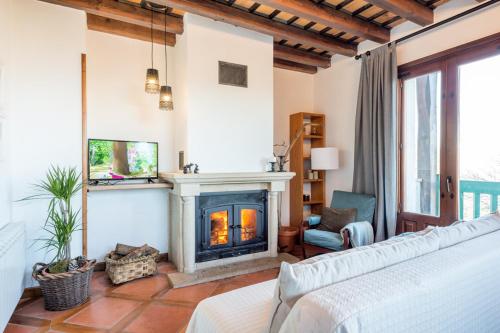 sala de estar con chimenea y sofá en El Aserradero, en La Alberca