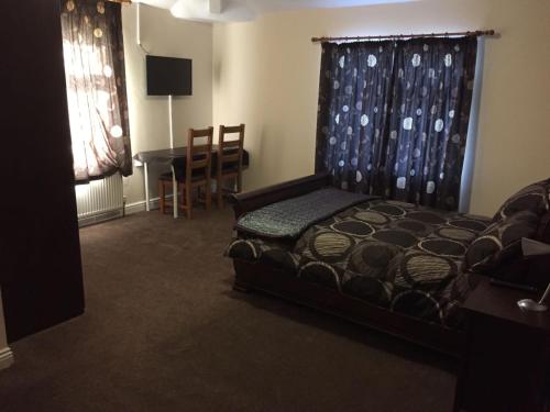 a bedroom with a bed and a table and a desk at Brookfield Hotel in Leeds