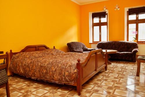 ヤーヒモフにあるApartments Střed Jáchymovのベッドルーム1室(ベッド1台、ソファ、椅子付)