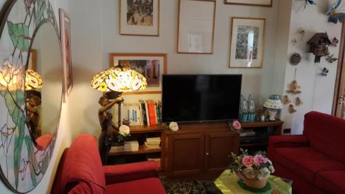 a living room with a television and a red couch at Albergo Le Rose in Pistoia