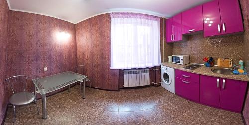 a kitchen with purple cabinets and a table and a sink at New VIP Verona APARTMENT 2019 Very Center in Kherson