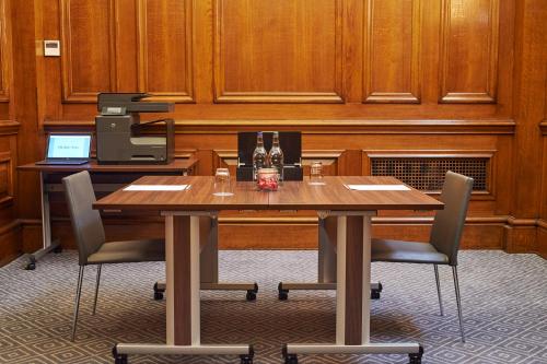 a conference room with a wooden table and chairs at Kimpton Clocktower by IHG in Manchester