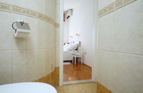 łazienka z toaletą i łóżko w pokoju w obiekcie Split on the beach, 2 floors & wide terrace w Splicie
