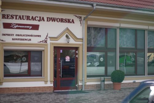 a store with a red door in front of a building at Dworek w Płoni in Szczecin-Płonia