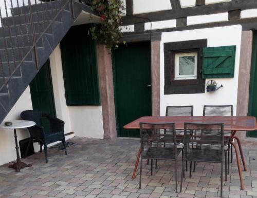 ブーウィラーにあるcharmant petit appartement en Alsaceの建物前のテーブルと椅子