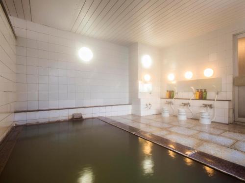 a pool of water in a bathroom with toilets at Toya Gokirakutei in Lake Toya