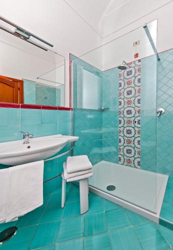 a bathroom with a tub and a sink and a shower at Hotel Pupetto in Positano