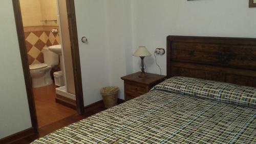 a bedroom with a bed and a bathroom with a toilet at La Posá CR CC 221 in Acehuche