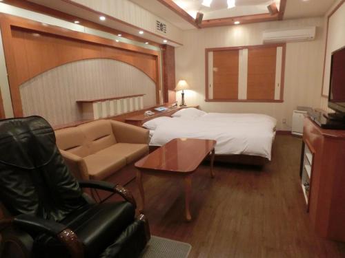 um quarto de hotel com uma cama e um sofá em Hotel Hyper Noah (Adult Only) em Sakai