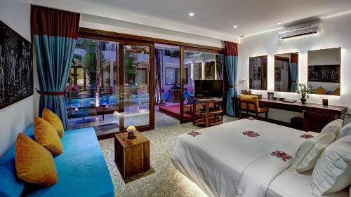 a hotel room with a bed and a desk and a television at Golden Temple Retreat in Siem Reap