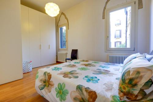- une chambre avec un lit doté d'un couvre-lit floral et d'une fenêtre dans l'établissement Rio Ca Foscari, à Venise