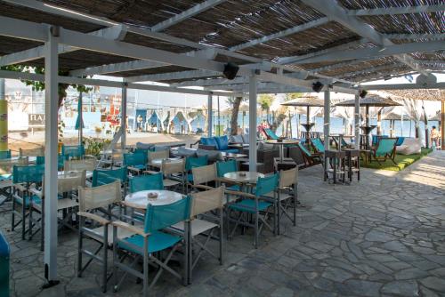 ein Restaurant mit blauen Stühlen und Tischen auf einer Terrasse in der Unterkunft Studio Nikos in Pythagoreio