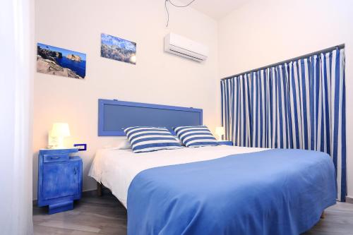 een slaapkamer met een blauw bed met 2 kussens bij La Posidonia Oceanica in Alghero
