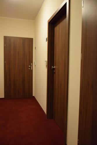 an empty room with two doors and a red carpet at Botanik Hostel in Poznań
