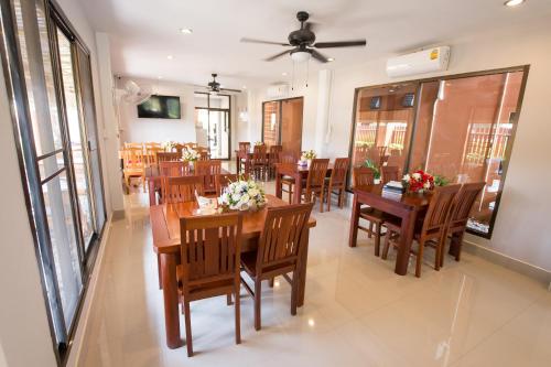 a dining room with wooden tables and chairs at Sri Siam Resort in Kanchanaburi City