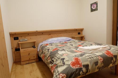 a bedroom with a bed with a wooden headboard at Santorsola Relax Hotel in Sant’Orsola