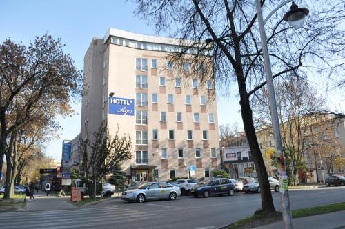 a building with cars parked in front of a street at Hotel Logos in Lublin
