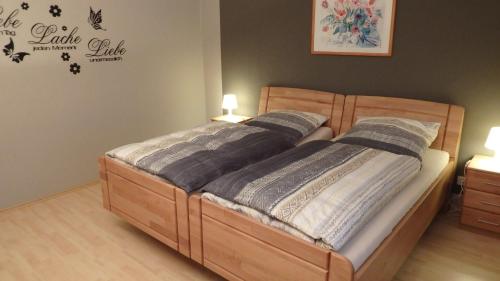sypialnia z drewnianym łóżkiem z 2 poduszkami w obiekcie Fischer w mieście Clausthal-Zellerfeld