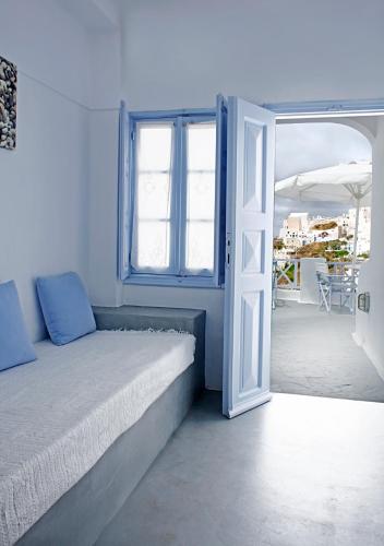 a bedroom with a bed and an open door at Armeni Village in Oia