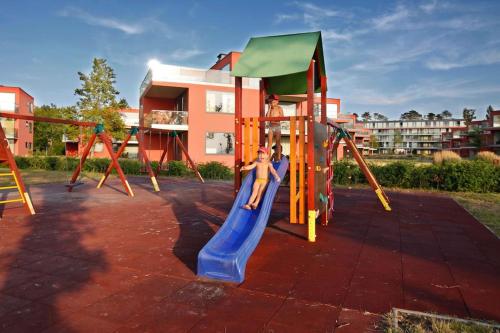 a child on a slide on a playground at Butique Apartman in Balatonlelle