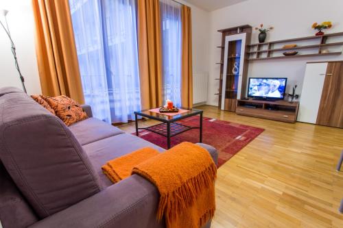 a living room with a couch and a tv at Colours Apartments Budapest in Budapest