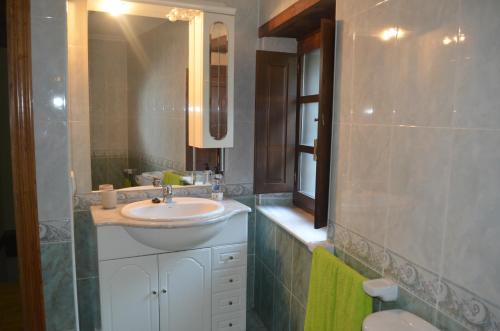 a bathroom with a sink and a mirror at La Corrada in Priede