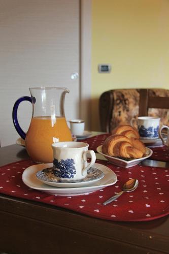 a table with a cup of tea and a plate of croissants at B&B Doria Valle Maira in Roccabruna