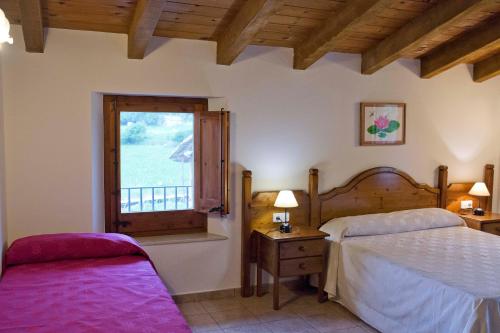 a bedroom with two beds and a window at Mas El Ferrés in Joanetes