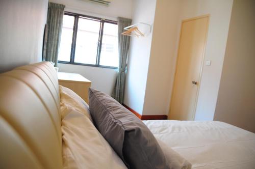 a bedroom with a bed and a window and a window at GRAYHAUS Guest House in Petaling Jaya