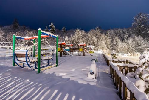 a playground in the snow with snow covered trees at Hotel TTS**** Spa&Wellness Covasna in Covasna