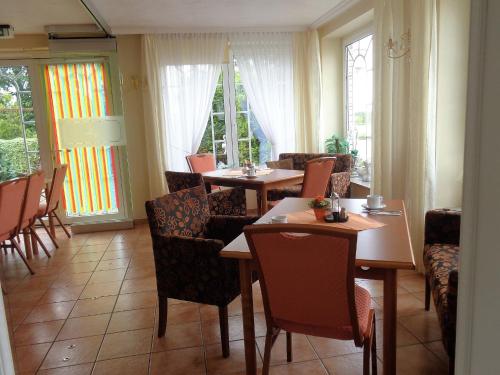 a dining room with tables and chairs and windows at Hotel Zur Lohe in Merzenich
