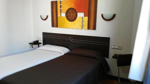 a bedroom with a bed and a painting on the wall at Santa Clara in Oviedo