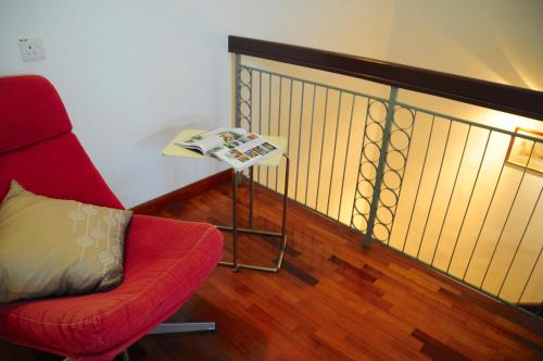 a living room with a red chair and a table at GRAYHAUS Guest House in Petaling Jaya
