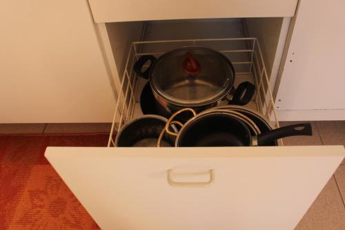 a pot and pans in a drawer in a kitchen at Bed & Breakfast Tiffany in Domodossola