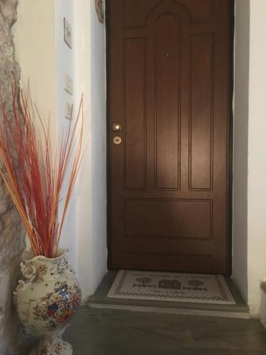 a brown door with a vase sitting next to it at Apartments Aurora Delle Rose in Assisi