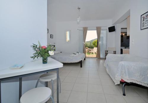 sala de estar con sofá, mesa y sillas en Elea Apartments, en Kálamos Kythira