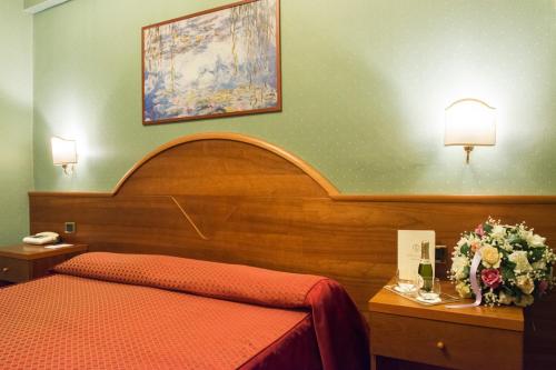 a hotel room with a bed and flowers on a table at Hotel Lido - Beach and Palace in Bolsena