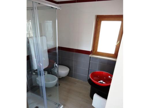 a bathroom with a red toilet and a glass shower at Villa Celeste B&B in Pontecagnano