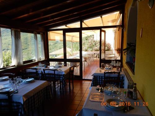 un restaurant avec des tables et des chaises bleues et des fenêtres dans l'établissement Casa Romantica in Liguria, à Testico