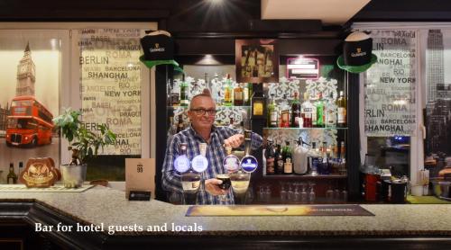 a man standing behind a bar holding a glass at Hôtel Bellerive in Lausanne